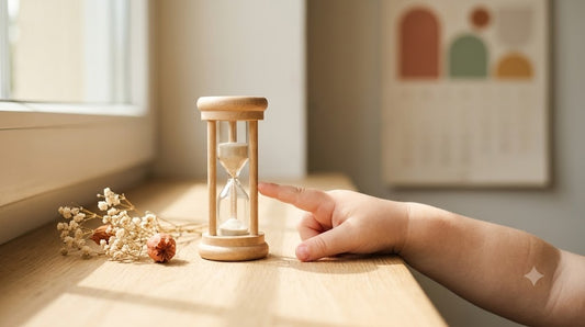 Kind betrachtet nachdenklich eine Sanduhr, im Hintergrund ein Kalender